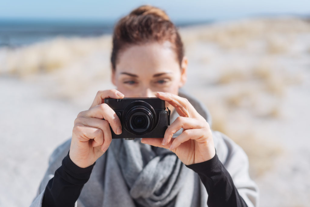 Frau fotografiert mit einer Kamera im Kurs Fotokurse für Anfänger